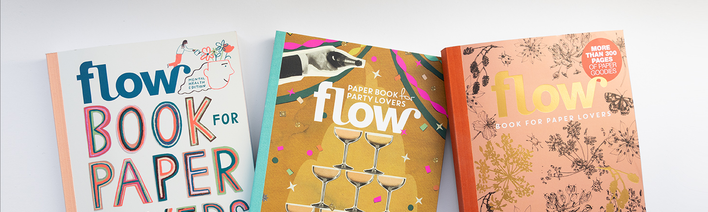 Drei bunte Magazine mit grafischen Illustrationen, gro&szlig;en Buchstaben und verschiedenen Papiertexturen nebeneinander auf wei&szlig;em Hintergrund.